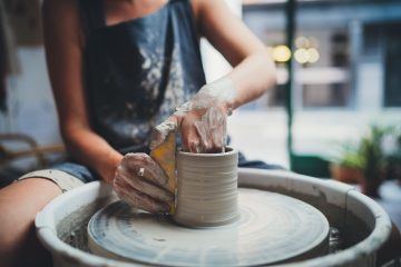 Artigiana lavora l'argilla per creare un vaso di ceramica