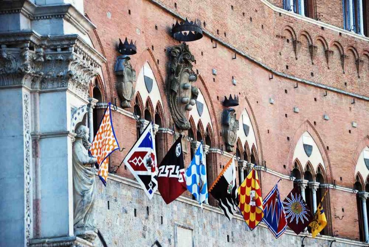 Bandiere delle Contrade di Siena in Piazza del Campo sul Palazzo comunale