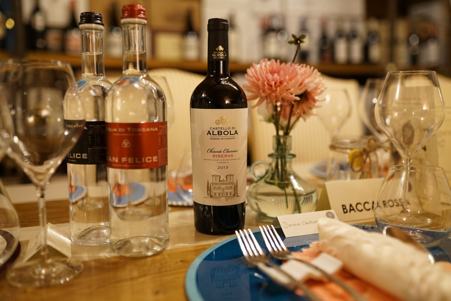 Tavolo apparecchiato con eleganza: in vista bottiglia di vino del CAlbiola e 2 di Acqua San Felice