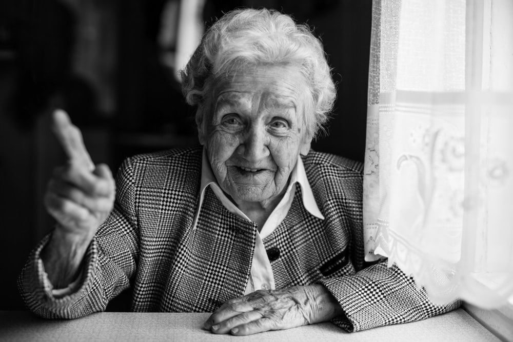 Foto in bianco e nero di anziana signora alla finestra