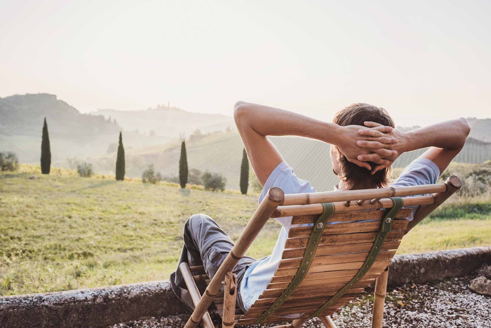 Ragazzo seduto guarda il panorama in Toscana
