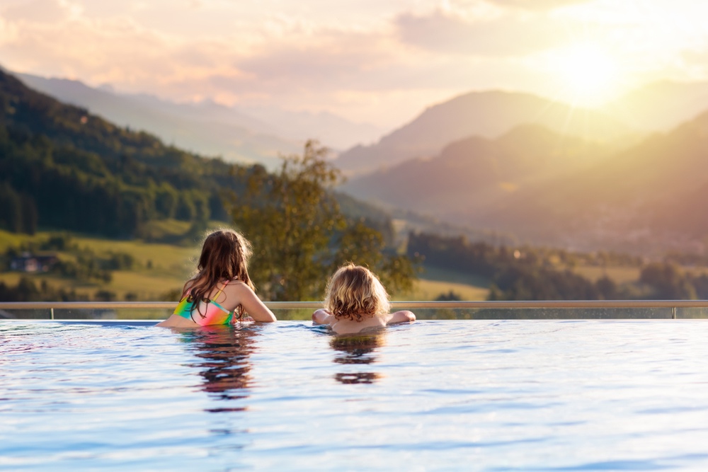 Bambini guardano il panorama da una piscina in Toscana