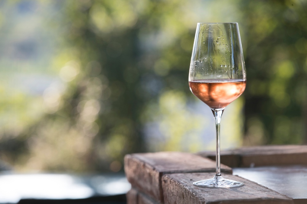 Un bicchiere di vino rosé toscano su tavolo di legno