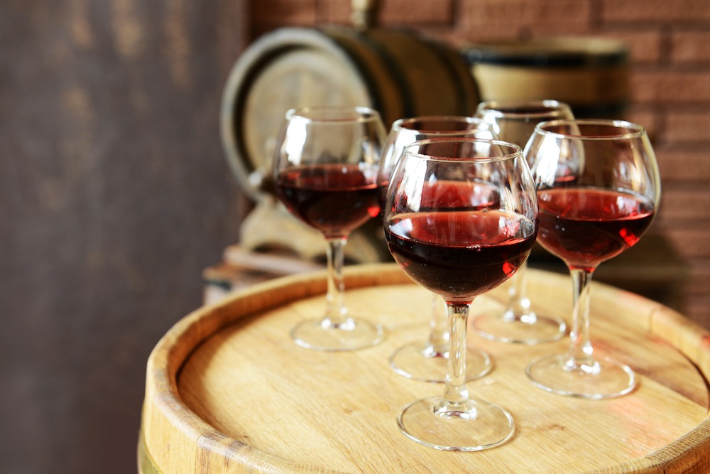 Bicchieri di vino rosso su una botte di legni