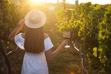 Giovane ragazza tra le vigne durante una degustazione di vino in Maremma