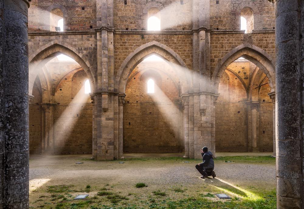 La luce solare filtra dalle finestre aperte dell'abbazia di San Galgano creando un effetto mistico