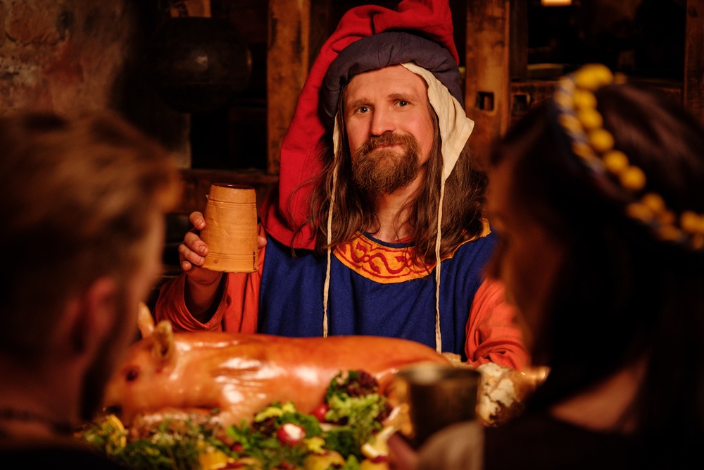 Uomo in costume brinda a un banchetto medievale