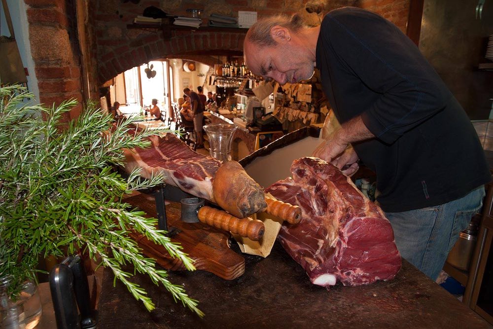 Taglio del prosciutto e bistecca cruda all'Osteria Acquacheta di Montepulciano