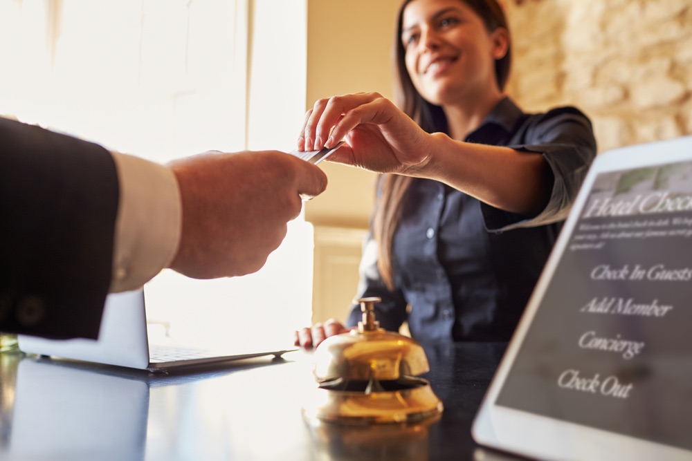 Receptionist in hotel consegna chiave a ospite