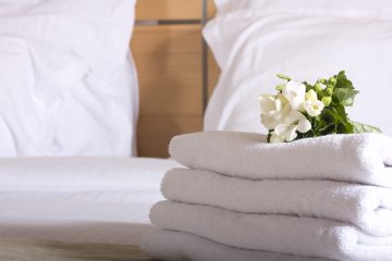 Interno di una camera di hotel con mazzo di fiori omaggio sul letto