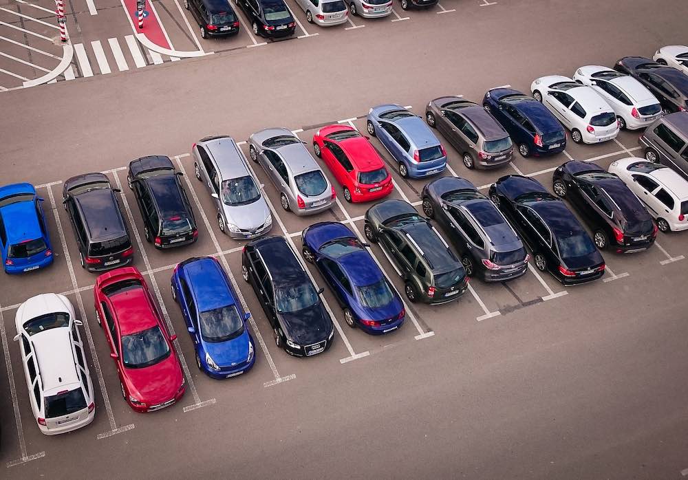 Parcheggio all'aperto all'aeroporto di Pisa con auto di vari colori