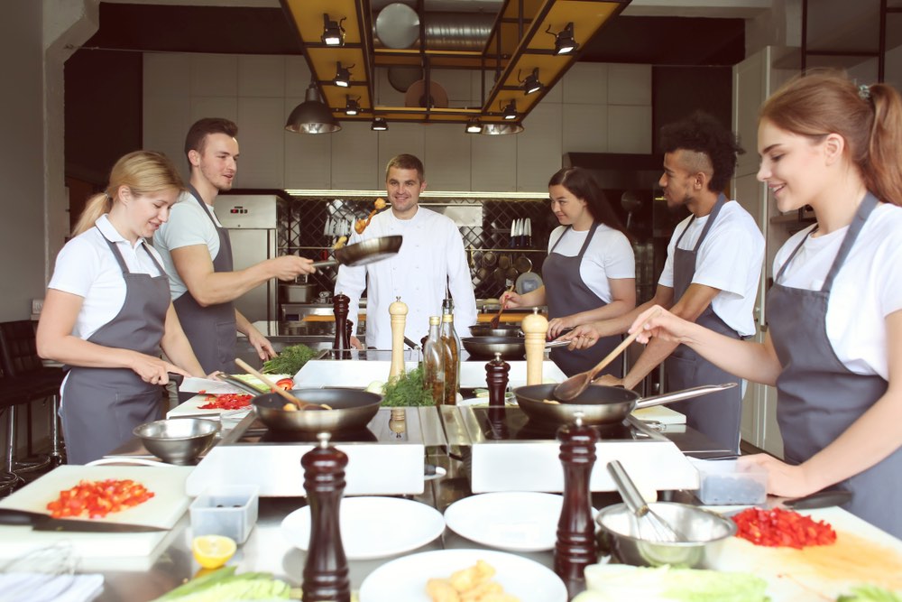 Chef con un gruppo di studenti in una scuola di cucina