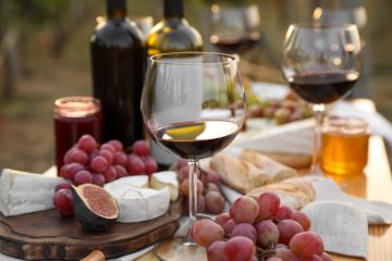 Calici di vino rosso su tavola imbandita per degustazione in Maremma