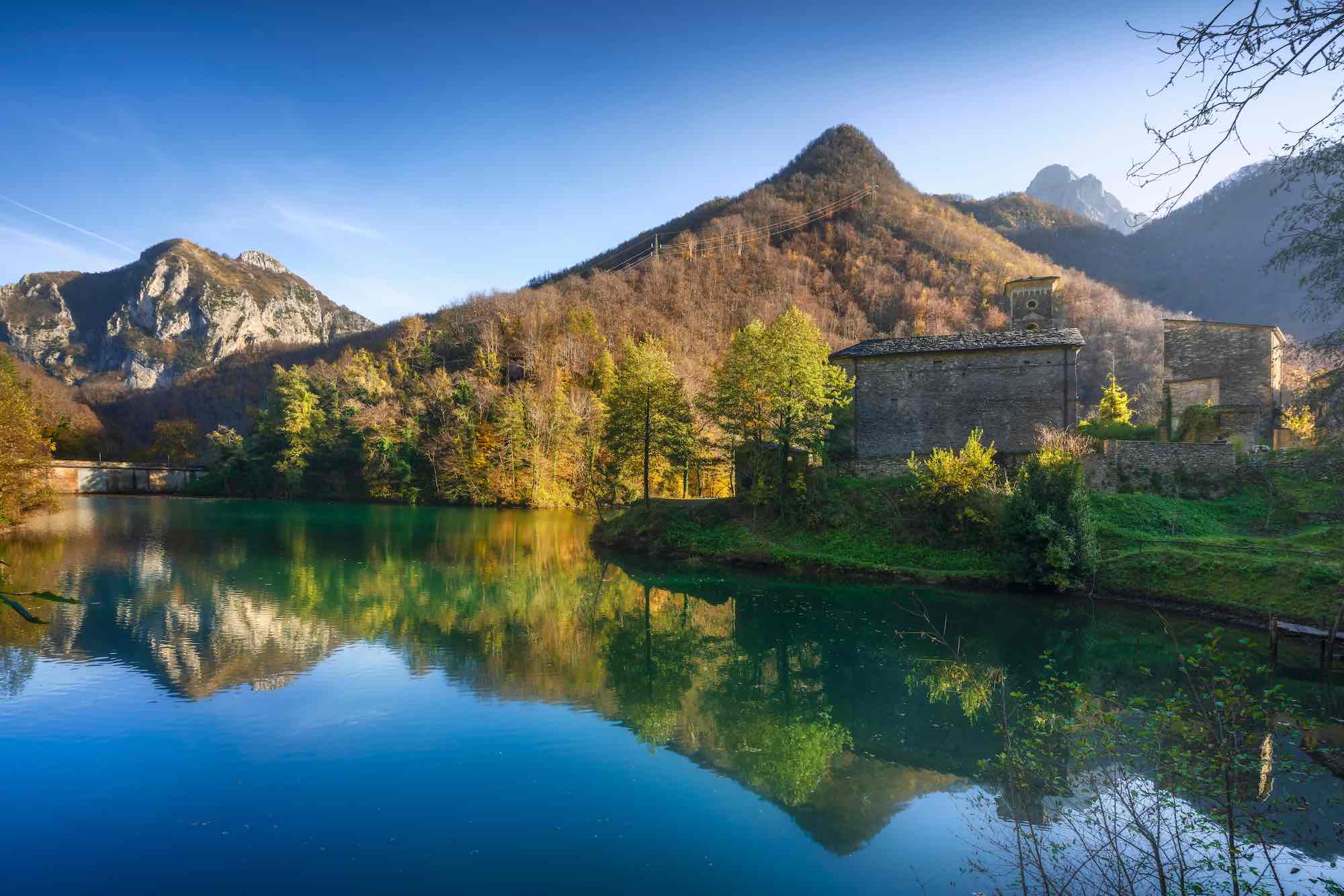 Isola Santa, borgo medievale, lago e Alpi Apuane in autunno. Garfagnana