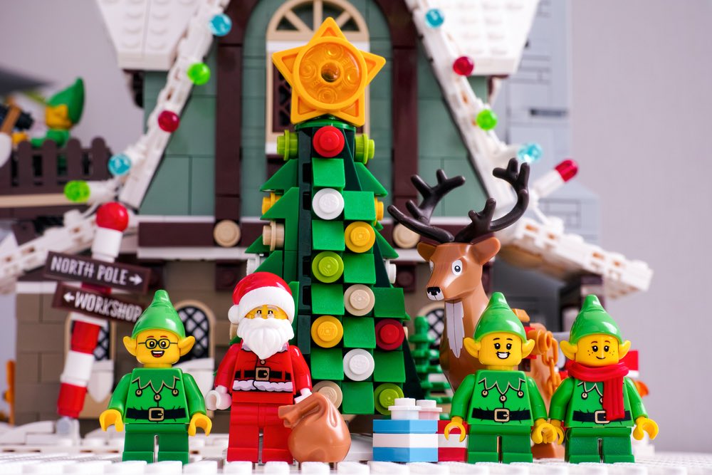 Babbo Natale, elfi e renne Lego in piedi vicino all'albero di Natale di fronte alla Casa del Club degli Elfi in mattoncini Lego®