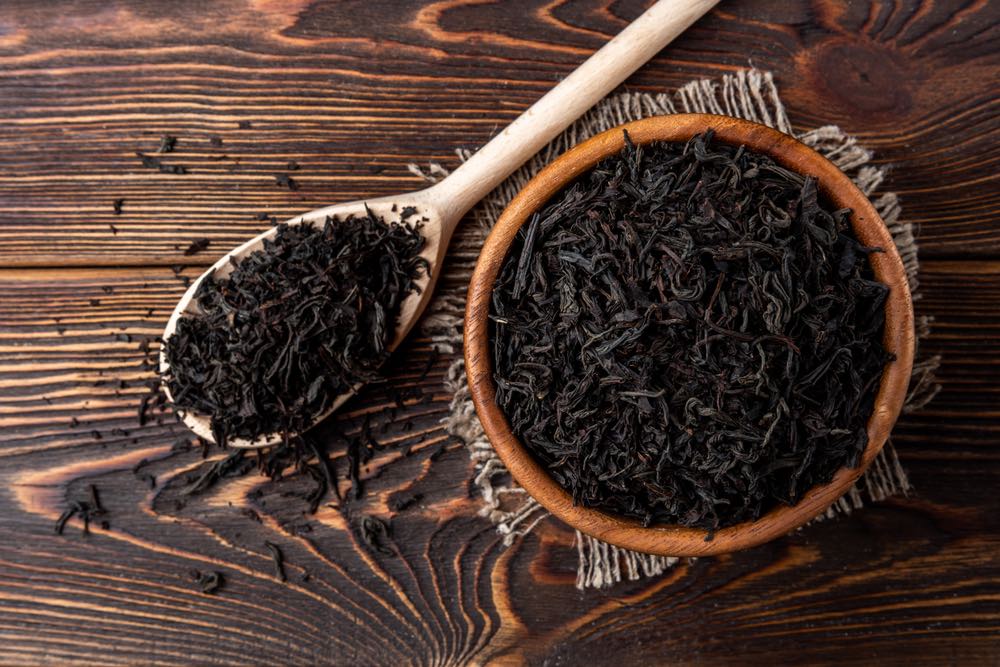 Tè nero su sfondo di legno scuro.