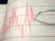 Primo piano dell'ago di una macchina sismografica che disegna una linea rossa su carta millimetrata per rappresentare l'attività sismica e i terremoti - Rendering 3D