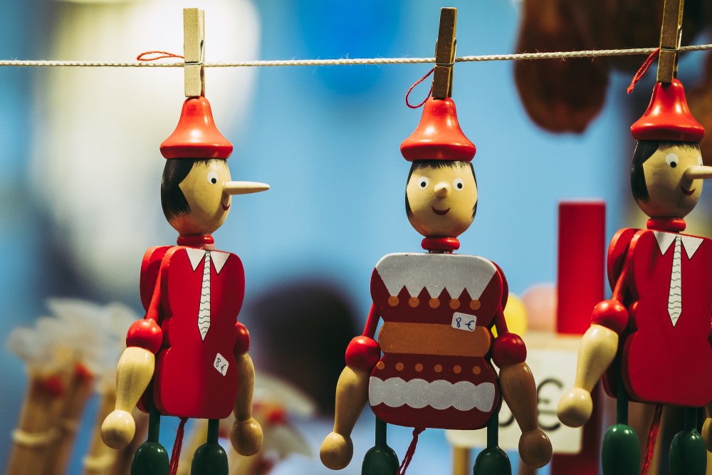 Piccoli Pinocchio di legno colorati, appesi in modo decorativo