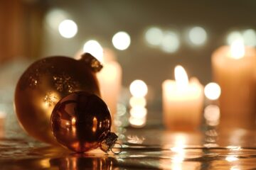 Palline di Natale dorate su sfondo a lume di candela