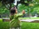 Bambina gioca in un giardino con le bolle di sapone