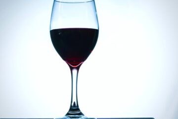 Bicchiere di vino rosso in controluce su sfondo bianco