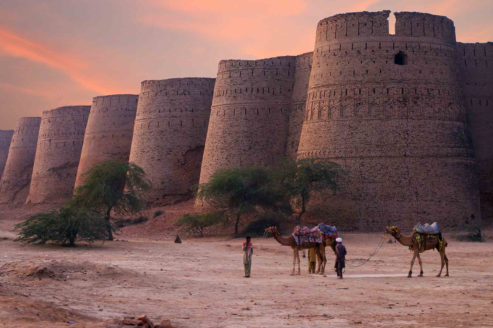 Fortezza in Pakistan al tramonto con persone con cammelli