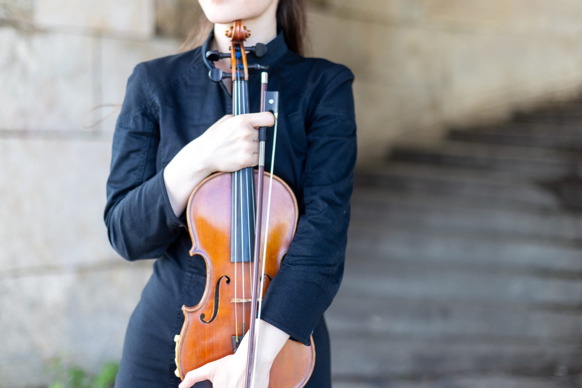 Ragazza con violino all'aperto in villa toscana