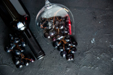 Calice di vino e bottiglia con grappolo d'uva