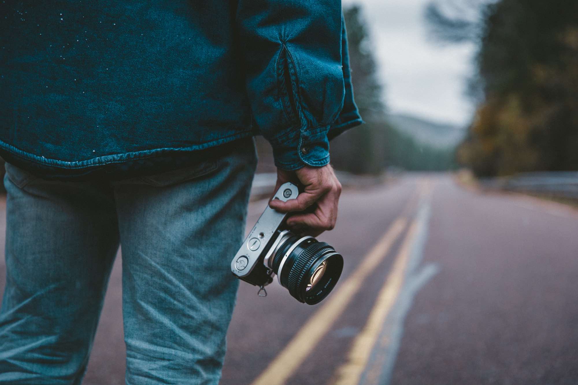 Fotografo su una strada con macchina fotografica in mano
