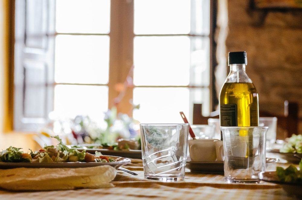 Bottiglia di olio di oliva su una tavola vicino alla finestra