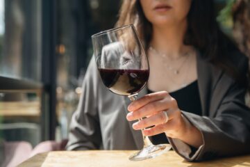 Primo piano di Bicchiere di vino rosso in mano ad una ragazza