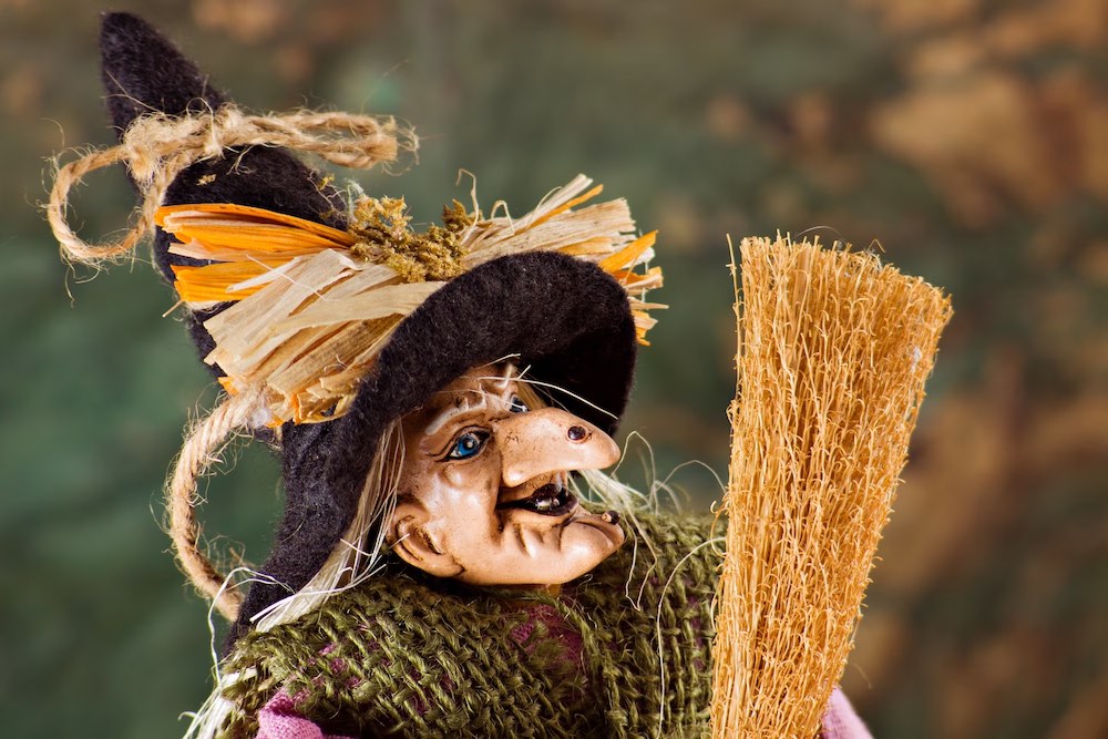 Una marionetta della Befana con la scopa in mano