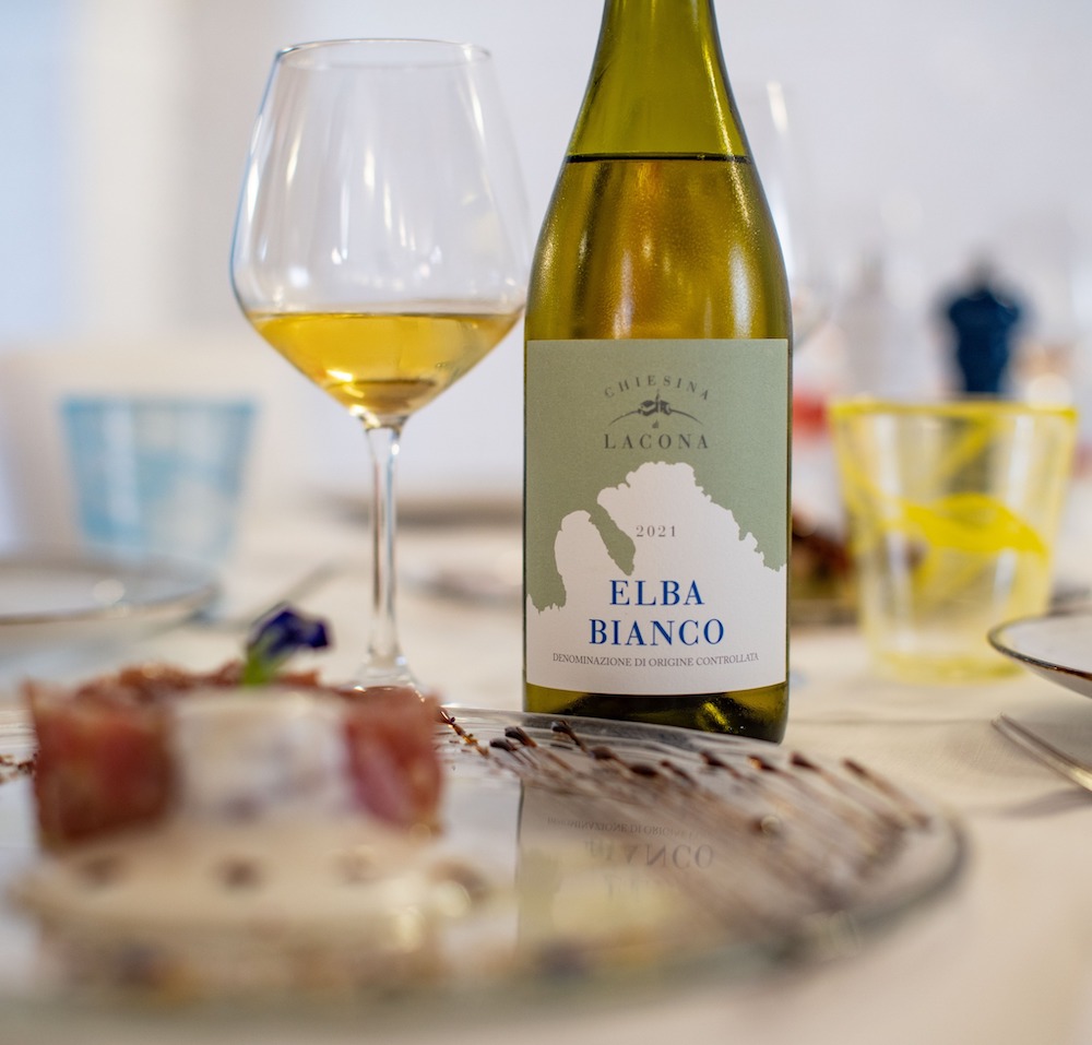 Bottiglia e calice di vino bianco di Chiesina di Lacona, vino dell'Elba