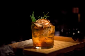 Cocktail su bancone di un bar con fetta di arancia