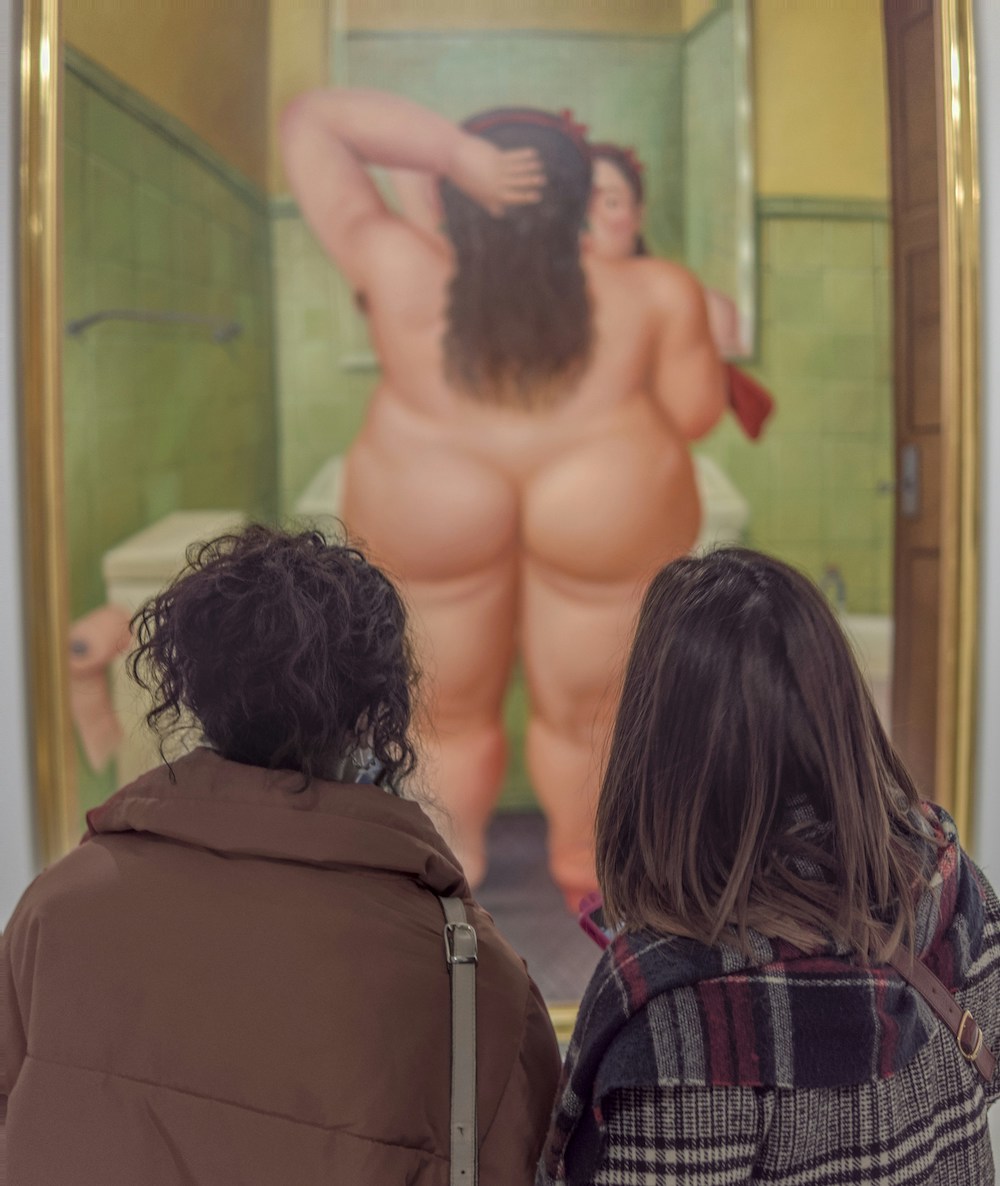 Due donne guardano un quadro di Fernando Botero