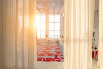 Camera in hotel di lusso con tende bianche al tramonto