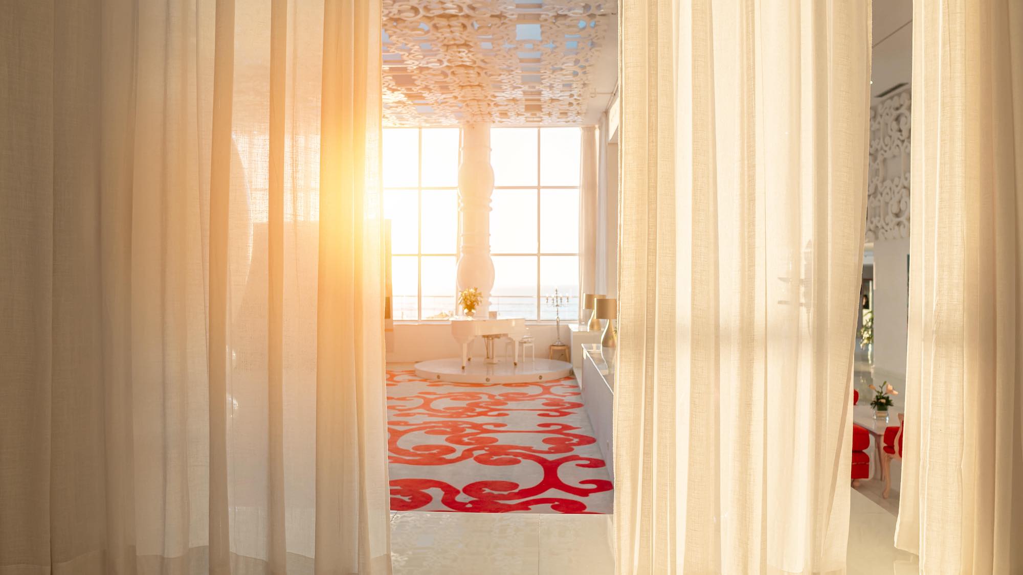 Camera in hotel di lusso con tende bianche al tramonto